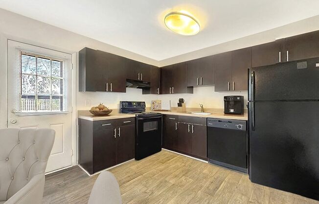 a kitchen with black appliances and a black refrigerator