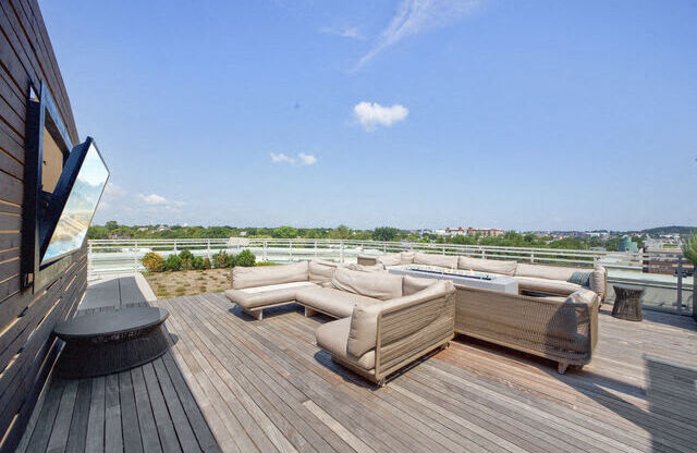 a terrace with couches and a table on a roof