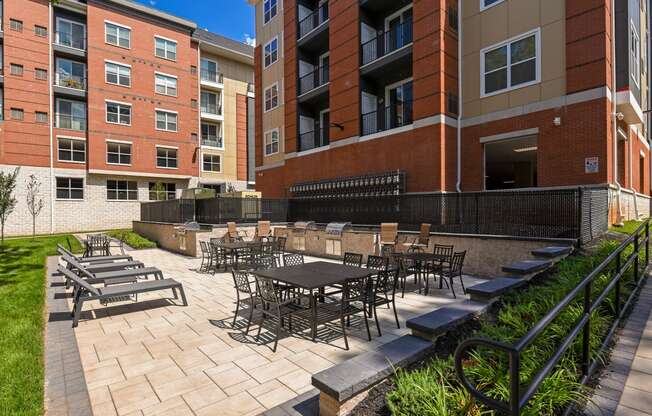 a patio with tables and chairs outside of an apartment building
