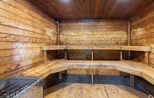 A wooden sauna with benches and a heater.