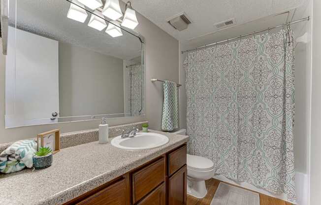 A bathroom with a patterned shower curtain and a white sink.
