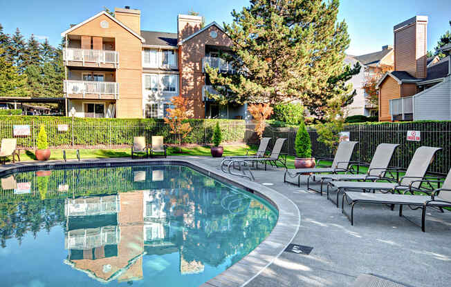 A pool in a backyard with a building in the background.