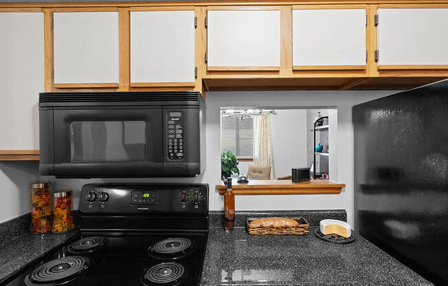 a kitchen with a black stove and a microwave