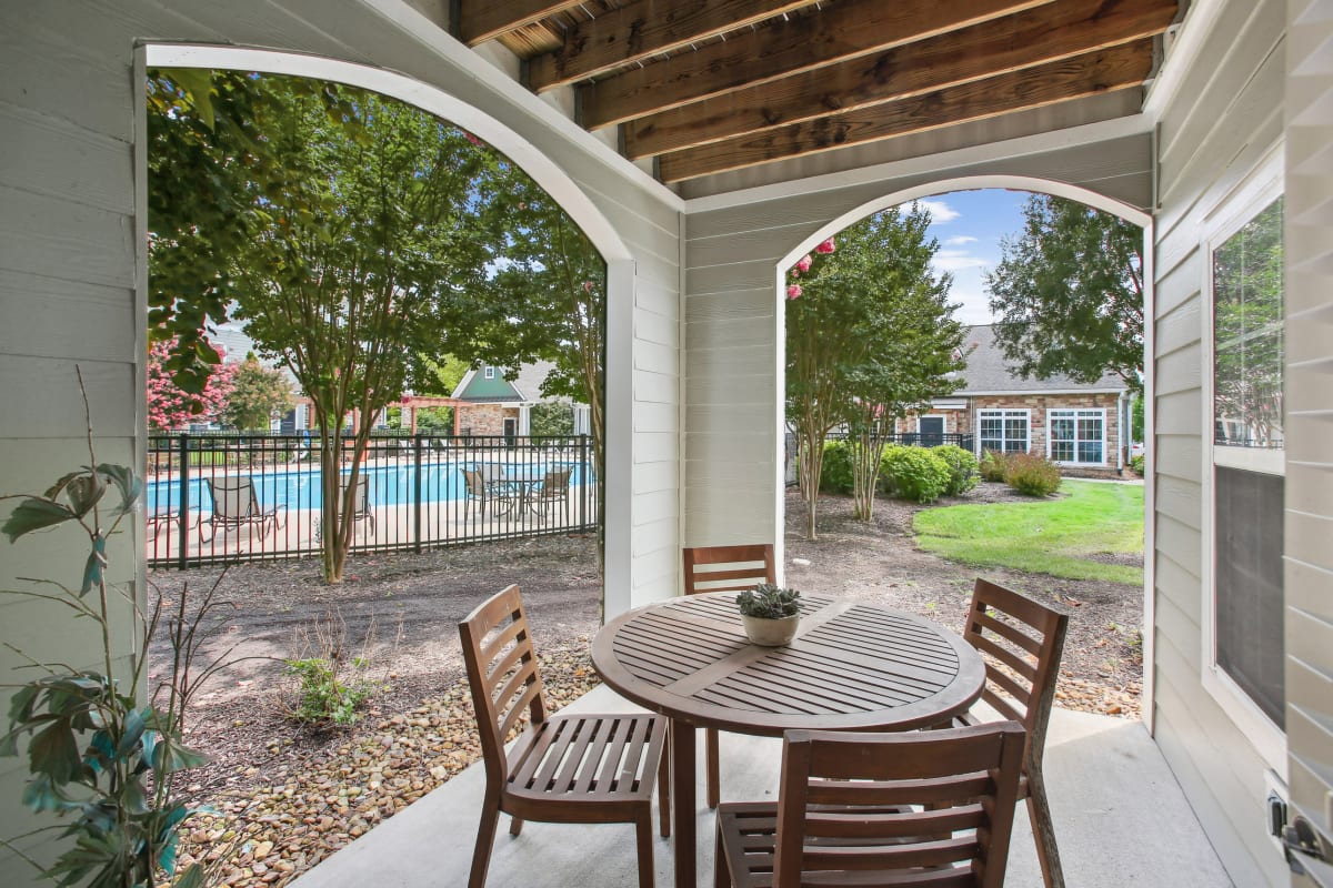 a patio with a table and chairs and a swimming pool