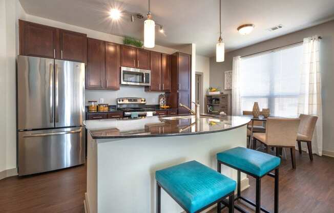 a kitchen with a large island with two stools in front of it