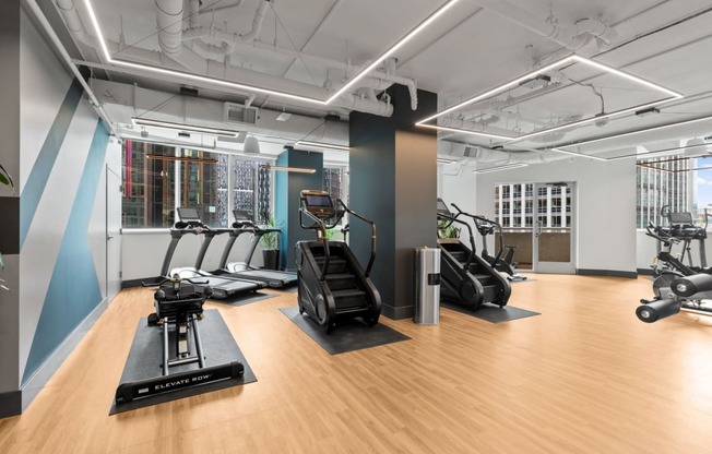 a gym with treadmills and other exercise equipment on a wood floor