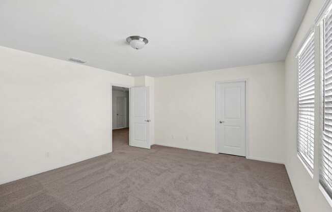 a bedroom with white walls and a carpeted floor