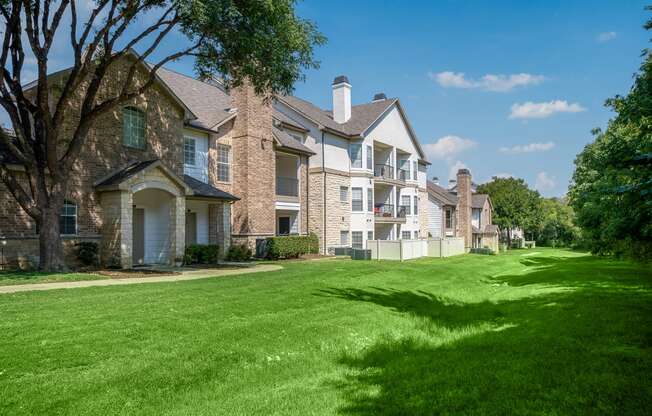 a green lawn in front of an apartment complex