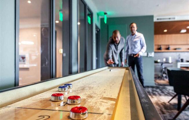 People standing next to a shuffleboard table at Circa Central