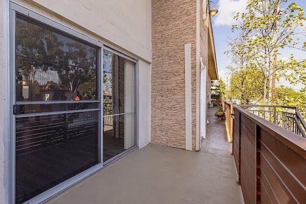 A balcony with a glass door and a railing.