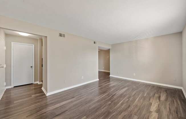 a bedroom with hardwood floors and white walls