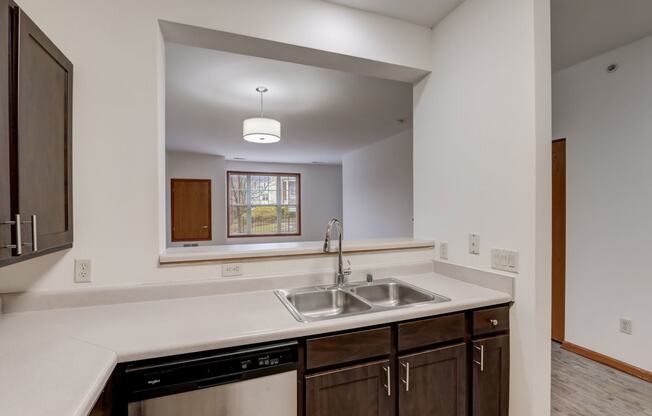 an empty kitchen with a sink and a window