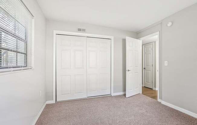 A room with a white door and a carpeted floor.