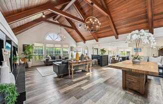 A spacious living room with a wooden ceiling and a large wooden coffee table.