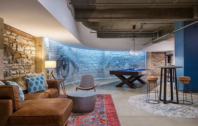 a living room with a pool table and a brick wall