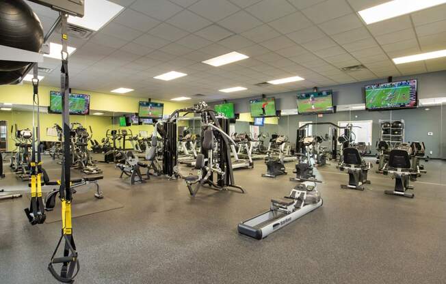 a gym with a lot of weights and cardio equipment at Veranda at Centerfield, Houston, Texas