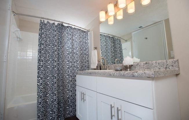 A bathroom with a shower curtain and a counter at Ridge Crossings Apartments, Hoover