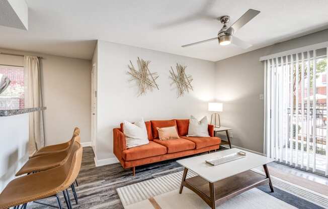 a living room with a couch and a table and a ceiling fan