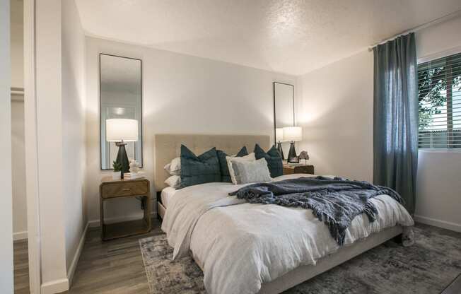 a bedroom with a large bed and a mirror on the wall