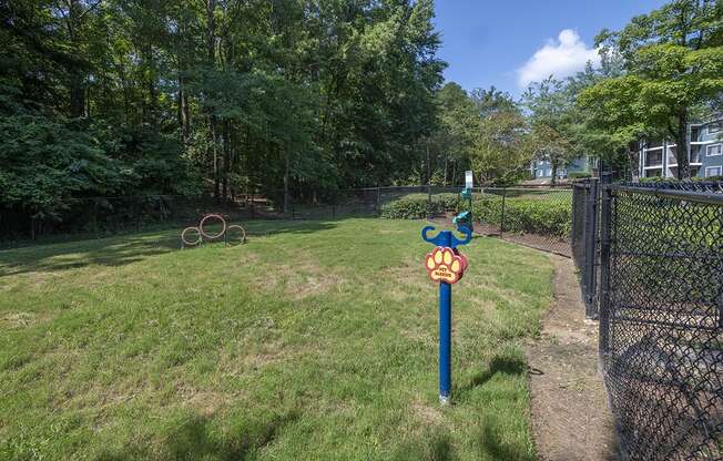 a post with a bark park sign in the middle of a fenced in off leash dog park at Wynnwood Vinings