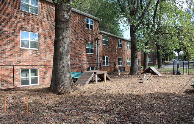A playground area in front of a brick building.
