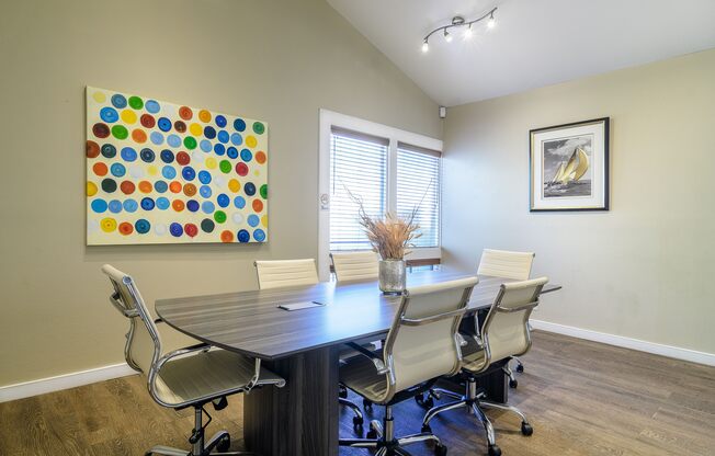 A conference room with a large table and chairs.
