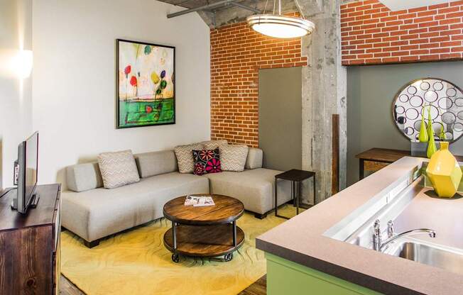 A living room with a couch, a coffee table, and a painting on the wall.