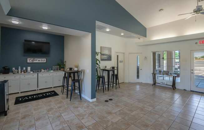 a clubhouse with a bar and a kitchen with stools
