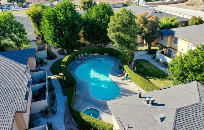 an aerial view of a swimming pool and hot tub in a backyard of a home