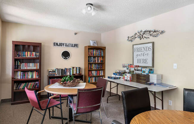 a library with a table and chairs and a bookcase filled with books