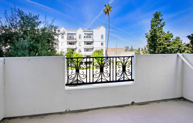 a balcony with a fence and a building in the background