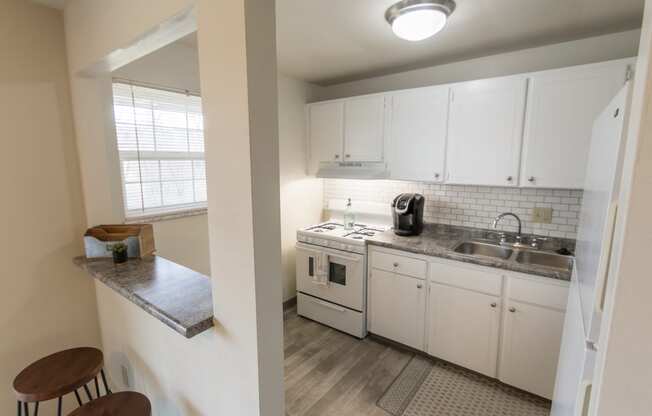 This is a photo of the kitchen and breakfast bar of the 1 bedroom, 631 square foot model apartment at Lake of the Woods Apartments in Cincinnati, OH.