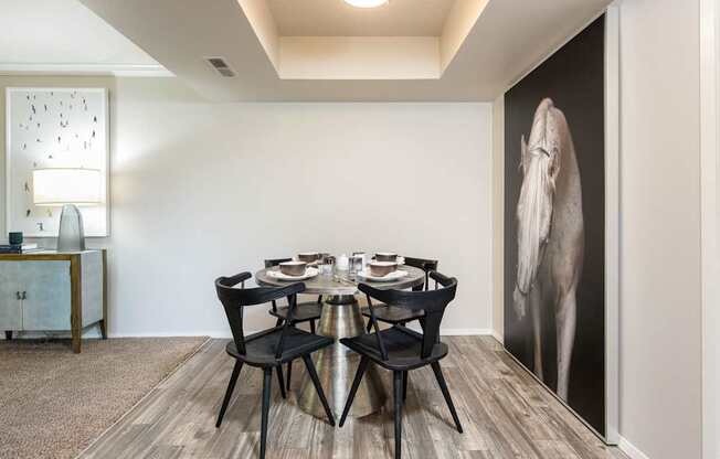 a dining room with a table and chairs and a large wall mural of an elephant