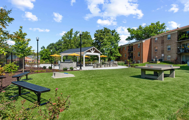 a park with picnic tables and a gazebo in front of a building