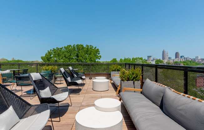 a rooftop deck with couches and chairs and a view of the Cleveland skyline at TREO Apartments, Cleveland, 44116