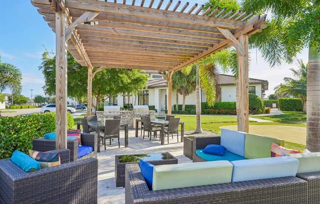 A wooden pergola over a patio with wicker furniture.
