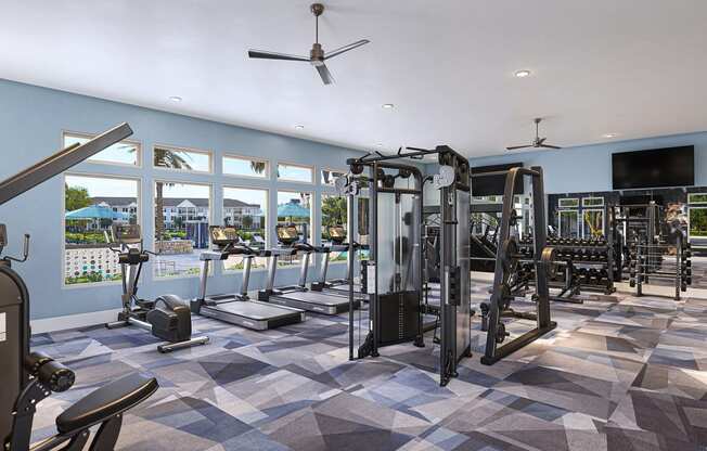 a gym  with weights and cardio machines and a view of a pool