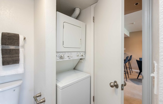 a washer and dryer in a small closet in a room with a door