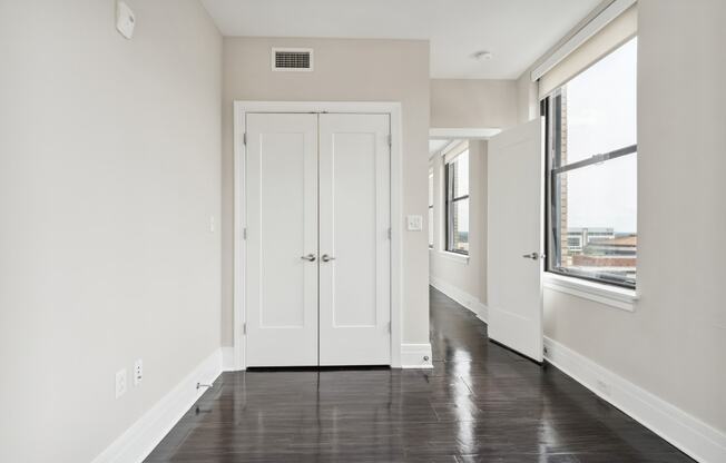 a bedroom with white walls and a black and white floor