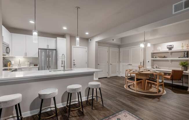 an open kitchen and living room with a bar and stools