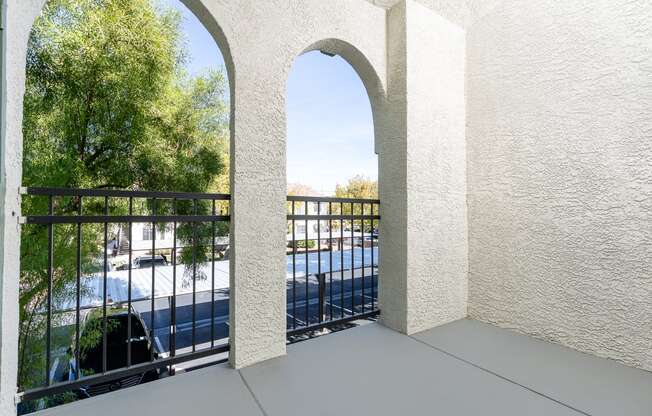 a balcony with a view of a pool and trees