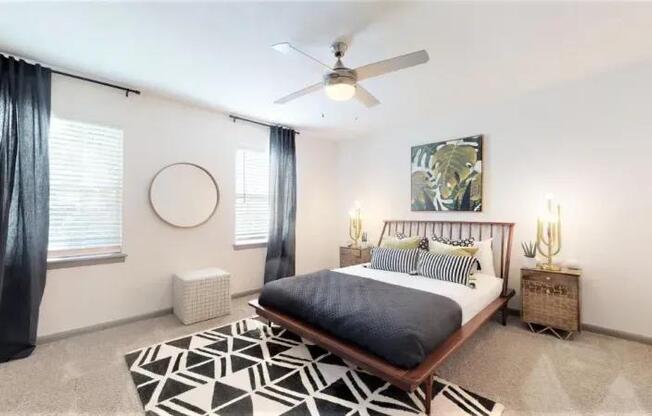 A bedroom with a bed, a ceiling fan, and a rug.