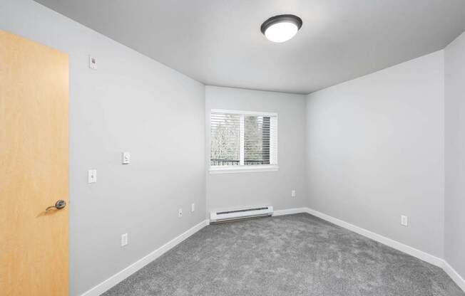 A room with a door, window, and carpeted floor.