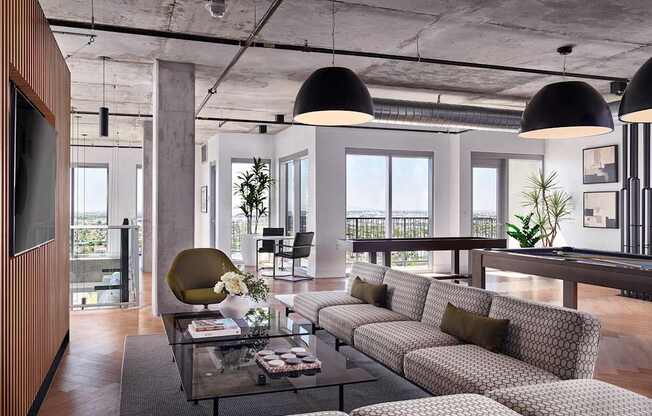 A modern living room with a glass coffee table and patterned sofas.