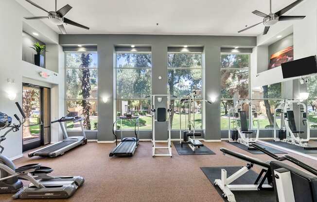 A spacious gym with treadmills, elliptical machines, and a rowing machine.