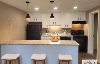 A kitchen with a counter and bar stools.