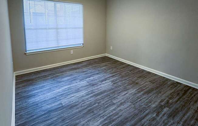 A room with a ceiling fan and a window with blinds.