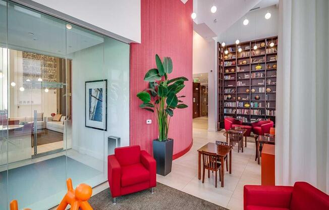 a lobby with red chairs and a plant