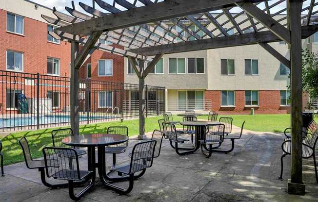 A patio with a table and chairs under a pergola.