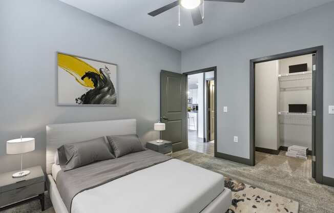 a bedroom with a white bed and a ceiling fan